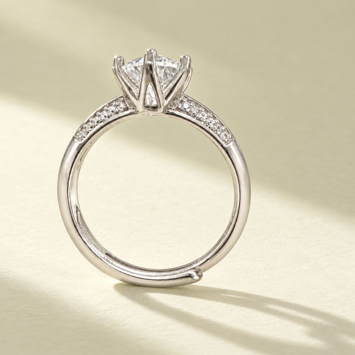 Side profile of the NEARHELD moissanite crown ring on a warm cream surface