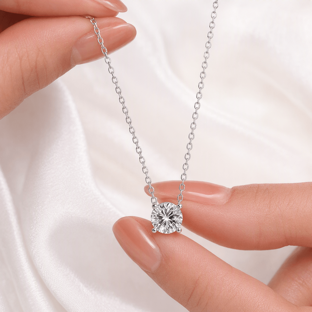 Four-prong moissanite pendant necklace held in hand