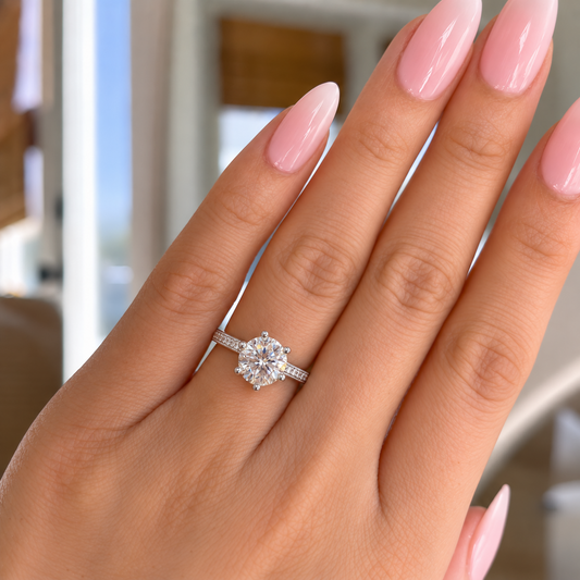 NEARHELD six-prong round moissanite ring worn on a hand in window light